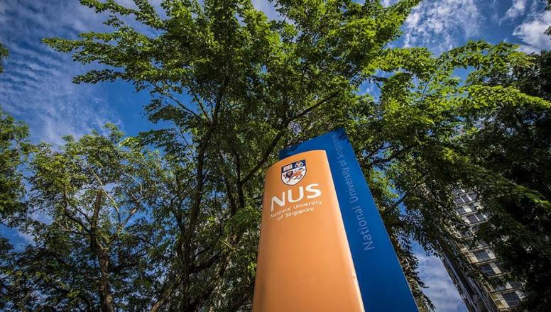 NUS Business School sign with school logo juxtaposed against trees and sky